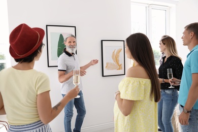 Group of people with guide at exhibition in art gallery