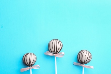 Photo of Tasty cake pops on light blue background, flat lay