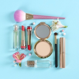 Flat lay composition with different decorative cosmetics and flowers on color background. Trendy makeup products
