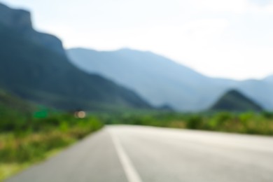 Blurred view of mountains and empty asphalt highway outdoors. Road trip