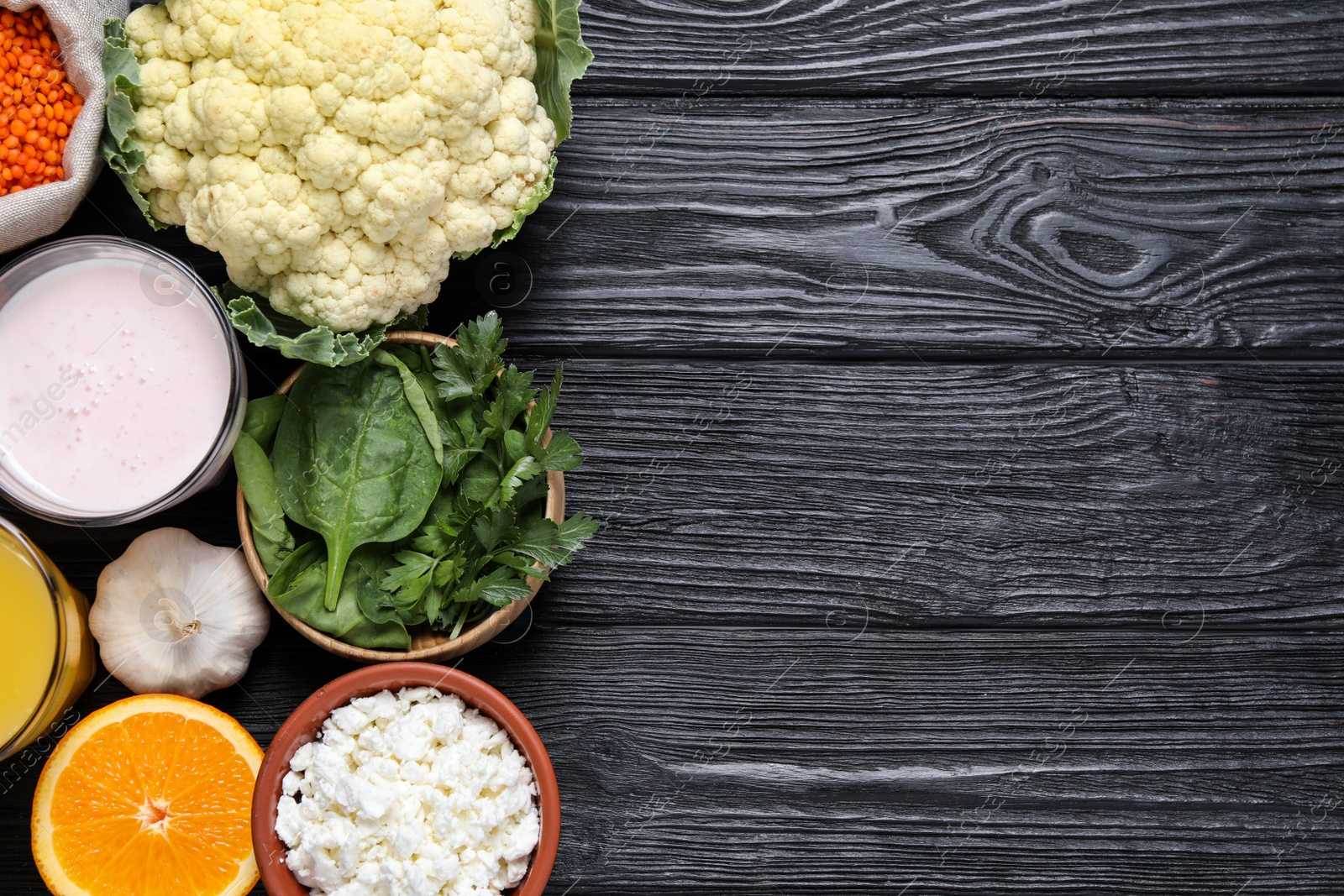 Photo of Set of natural food high in calcium on black wooden table, flat lay. Space for text