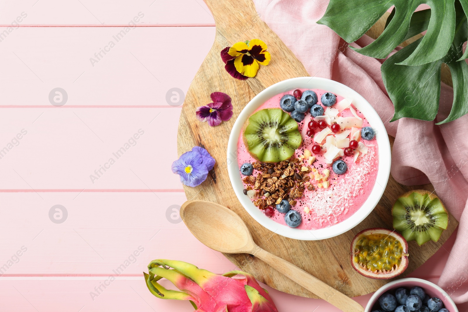 Photo of Flat lay composition with tasty smoothie bowl on pink wooden table. Space for text