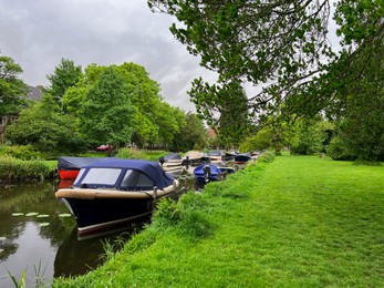 Beautiful view of green lawn near canal with different boats
