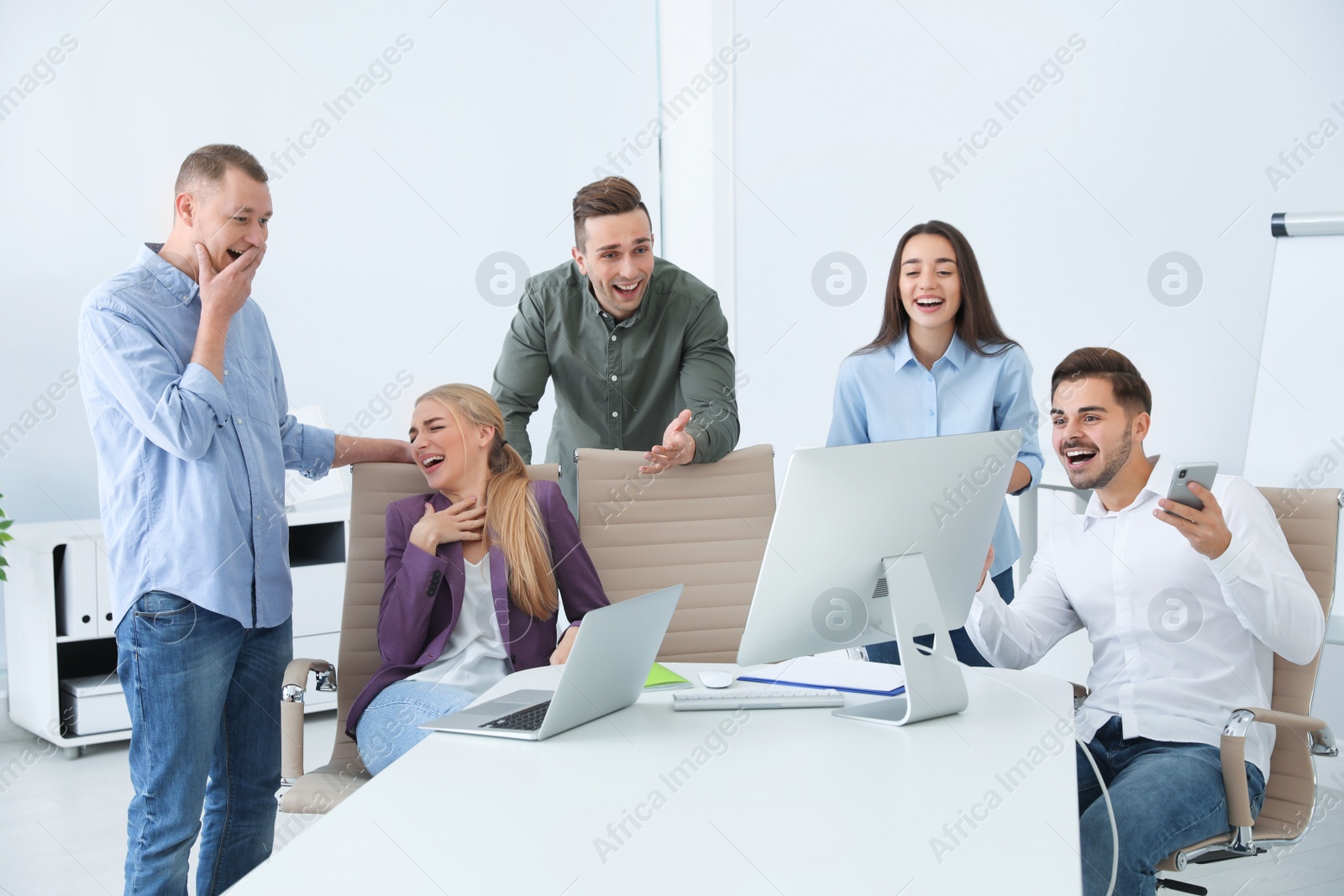 Photo of Group of colleagues laughing together in office