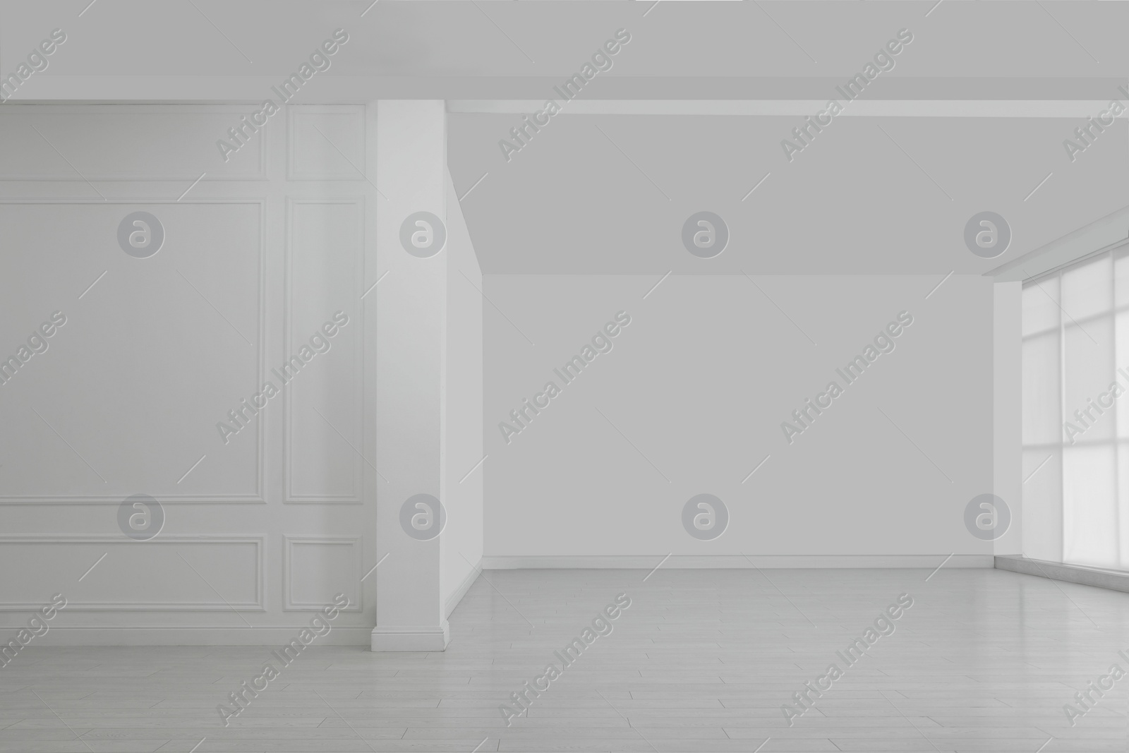 Photo of Empty room with white walls and laminated flooring