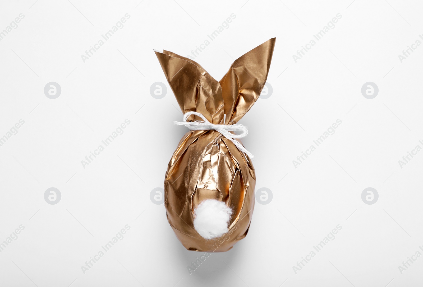 Photo of Easter bunny made of shiny gold paper and egg on white background, top view