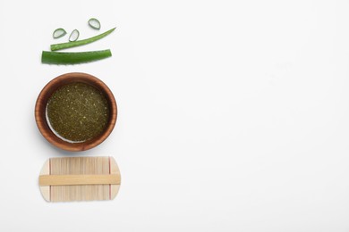 Homemade hair mask in bowl, aloe and bamboo comb on white background, top view