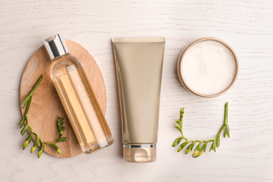 Flat lay composition with cosmetic products on white wooden table