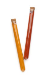 Photo of Glass tubes with turmeric and paprika on white background, top view