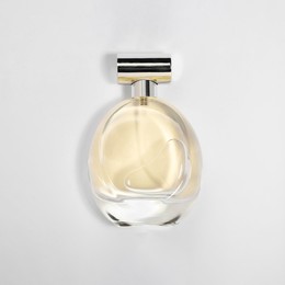 Luxury women's perfume in bottle on white background, top view