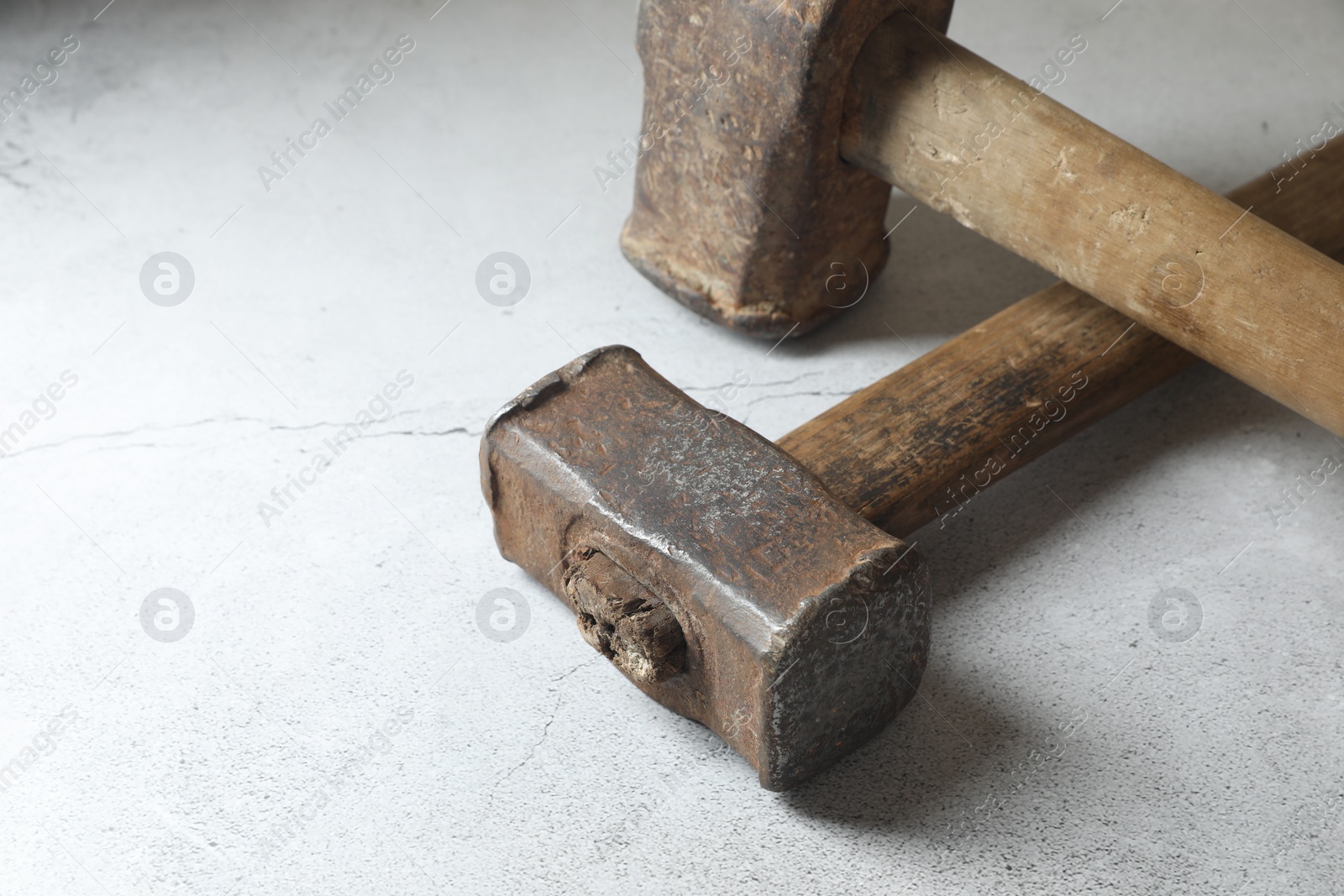 Photo of Two sledgehammers on grey background, closeup. Space for text