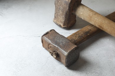 Two sledgehammers on grey background, closeup. Space for text