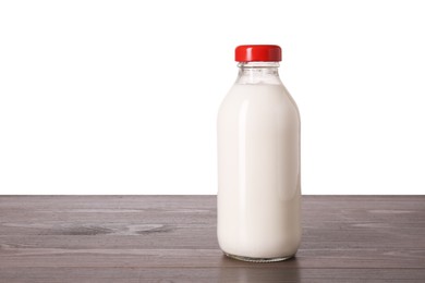Bottle of tasty milk on wooden table against white background