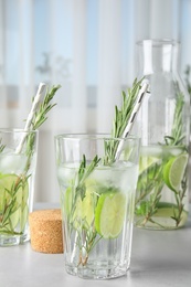 Photo of Tasty refreshing cocktail with rosemary and lime on table