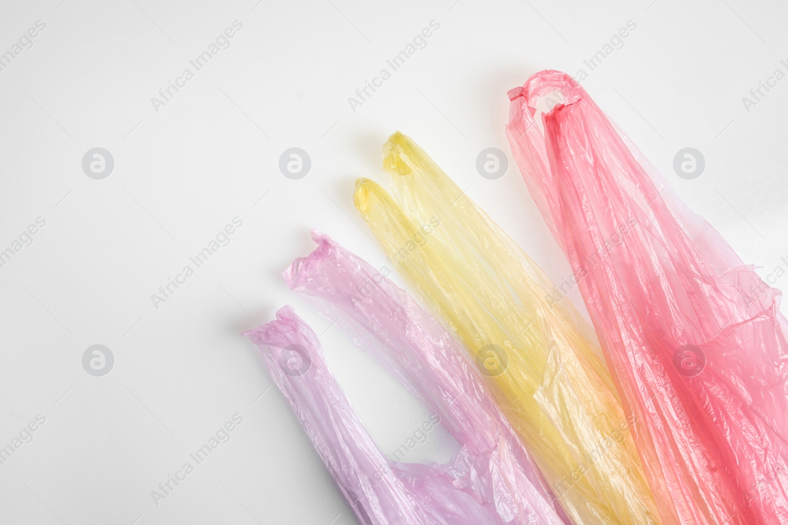 Photo of Color plastic bags isolated on white, top view