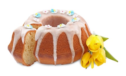 Festively decorated Easter cake and yellow tulips on white background