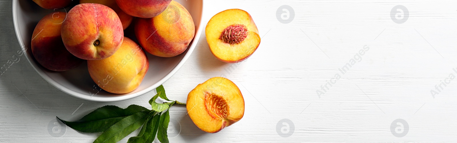 Image of Fresh ripe peaches on white wooden table, top view. Banner design with space for text