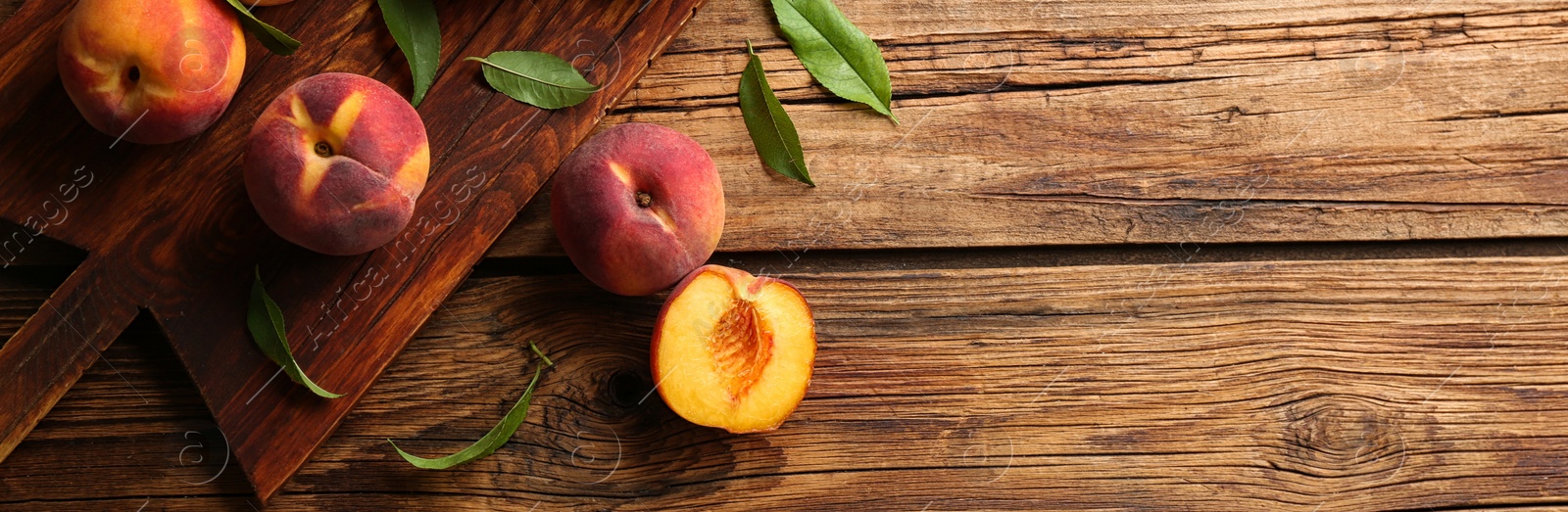 Image of Fresh ripe peaches on wooden table, top view. Banner design with space for text