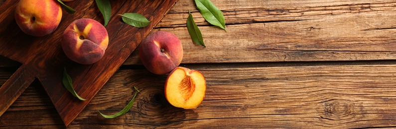 Image of Fresh ripe peaches on wooden table, top view. Banner design with space for text