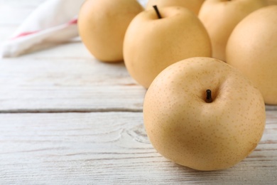 Photo of Ripe apple pears on white wooden table, closeup. Space for text