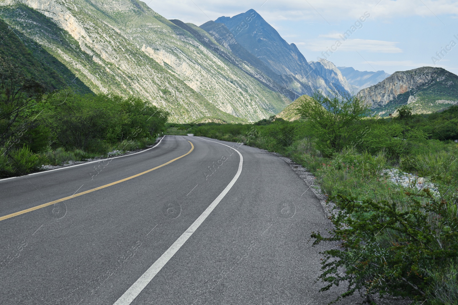 Photo of Beautiful view of empty asphalt highway near mountains outdoors. Road trip