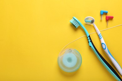 Photo of Flat lay composition with dental floss and different teeth care products on yellow background. Space for text