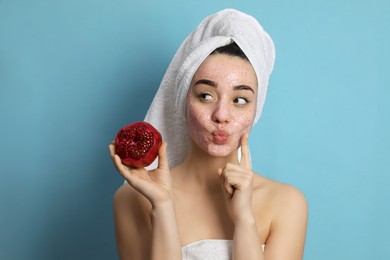 Photo of Woman with pomegranate face mask and fresh fruit on light blue background