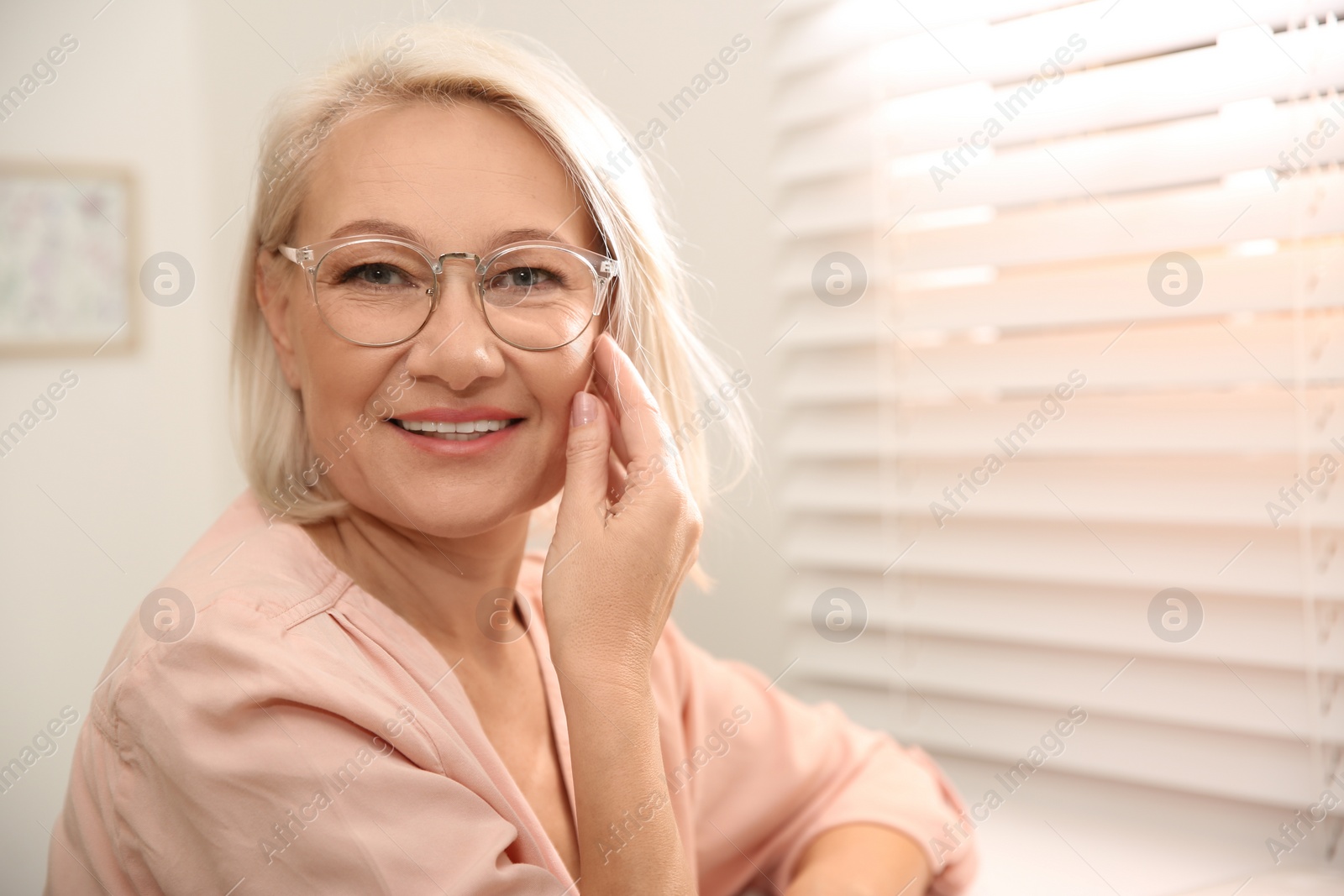 Photo of Beautiful mature woman in glasses at home. Space for text