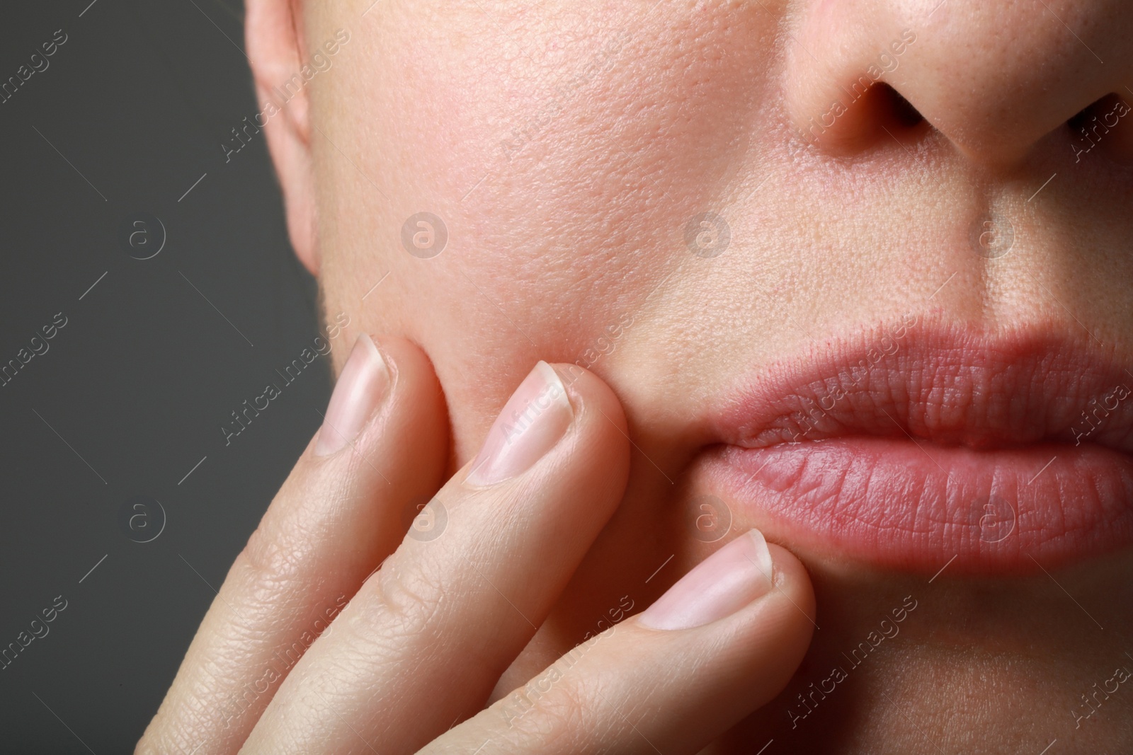 Photo of Closeup view of woman with healthy skin on grey background