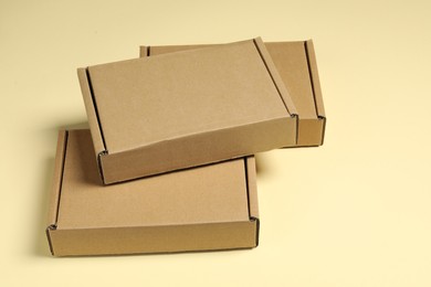 Photo of Many closed cardboard boxes on pale yellow background
