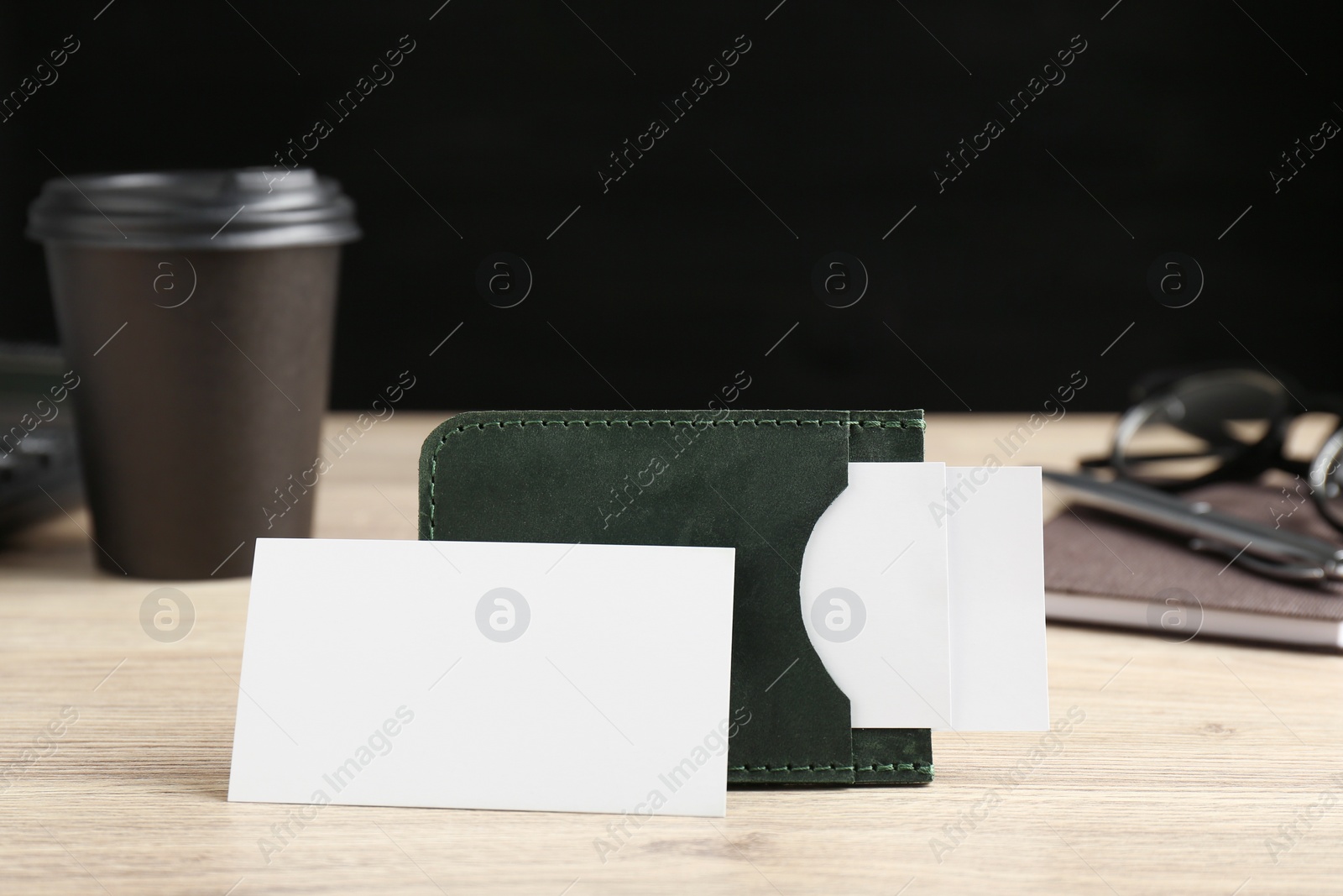 Photo of Leather business card holder with blank cards on wooden table