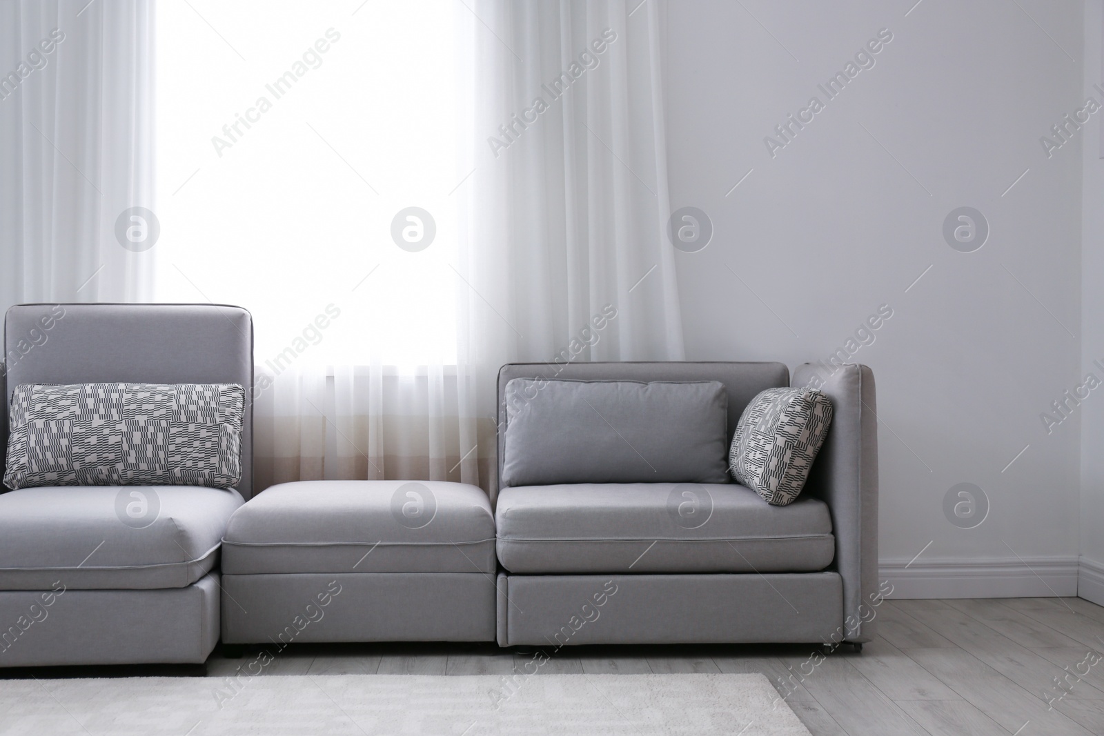 Photo of Simple living room interior with comfortable sofa near window