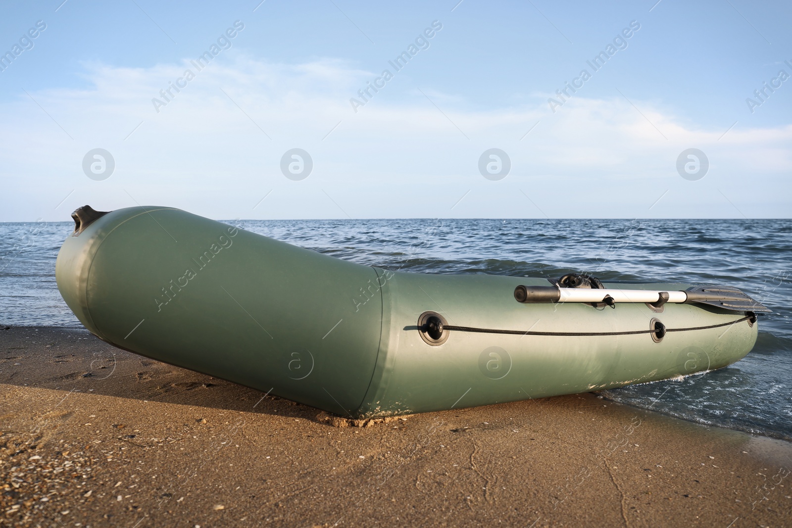 Photo of Inflatable rubber fishing boat on sandy beach near sea