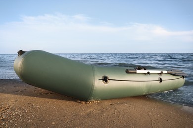 Inflatable rubber fishing boat on sandy beach near sea