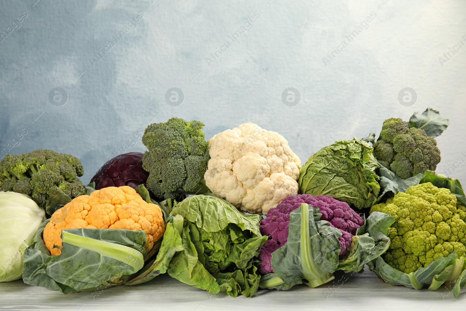 Photo of Different cabbages on wooden table. Healthy food