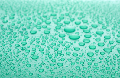 Water drops on turquoise background, closeup view