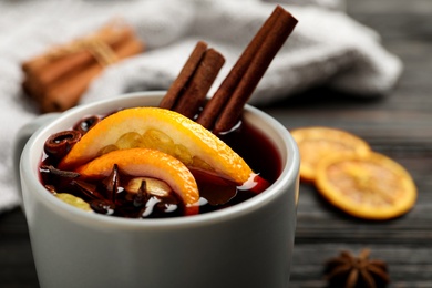 Photo of Cup of tasty mulled wine with spices, closeup