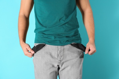 Man showing empty pockets on color background, closeup