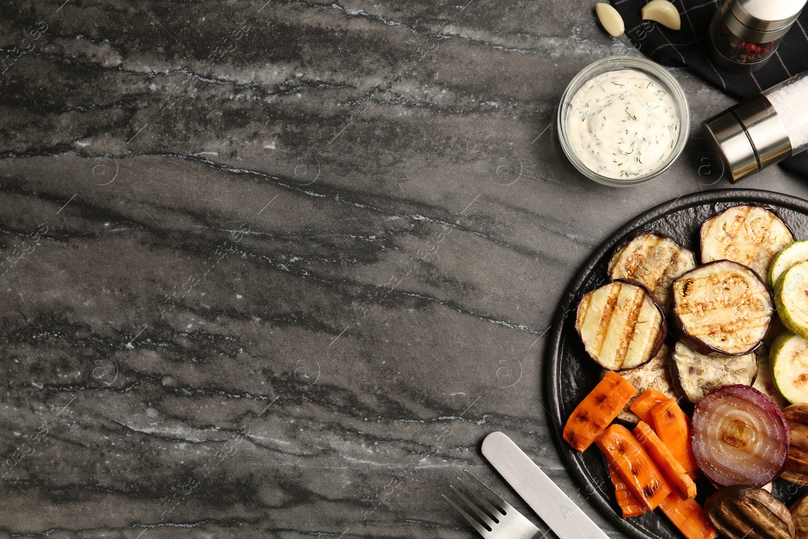 Photo of Delicious grilled vegetables and mushrooms served on black table, flat lay. Space for text