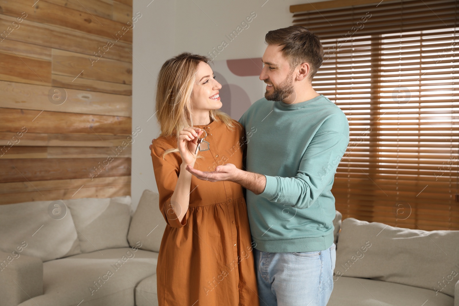 Photo of Happy young couple with key in new house