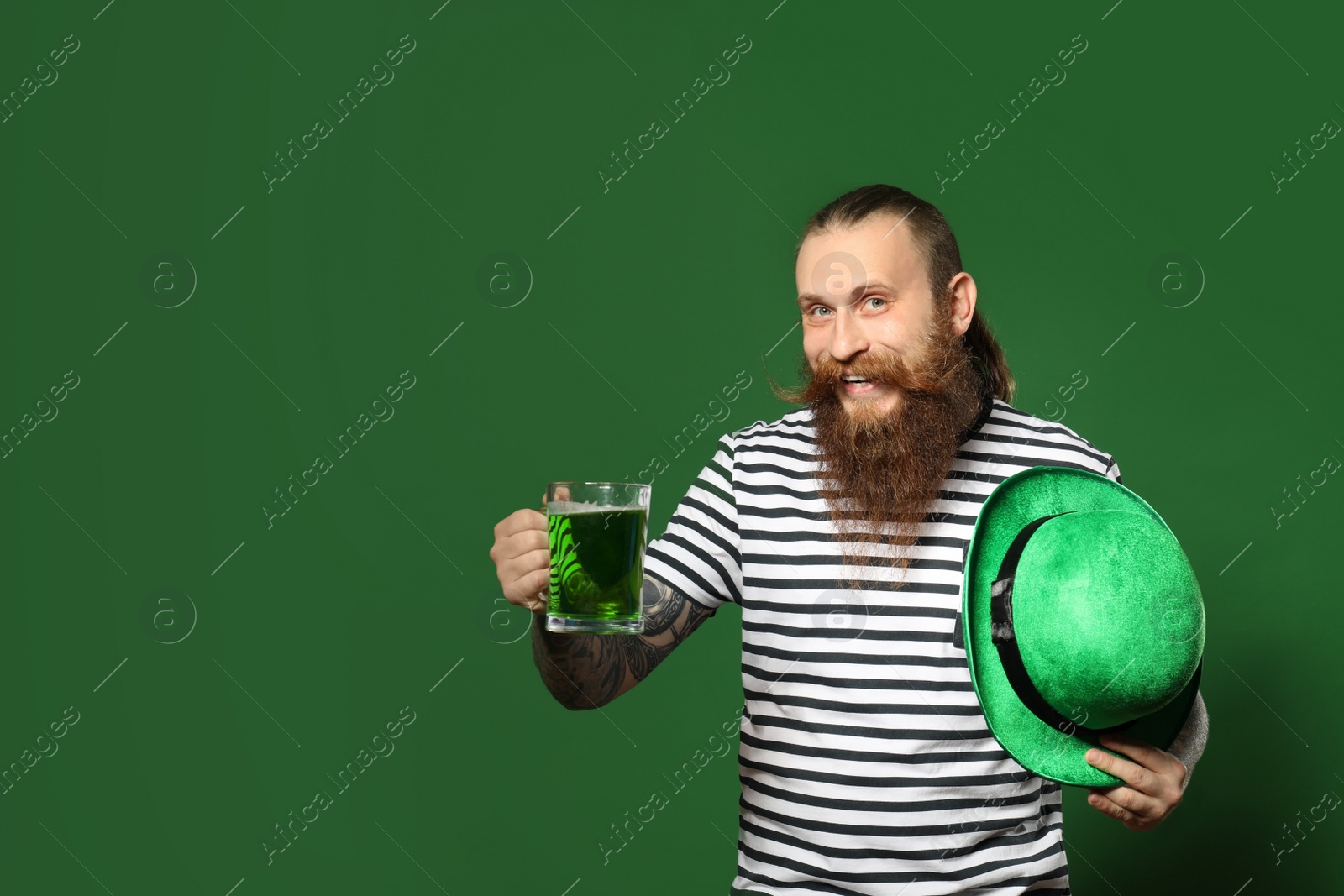 Photo of Bearded man with green beer on color background, space for text. St. Patrick's Day celebration