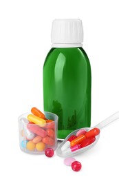 Bottle of syrup, measuring cup, plastic spoon with pills on white background. Cough and cold medicine