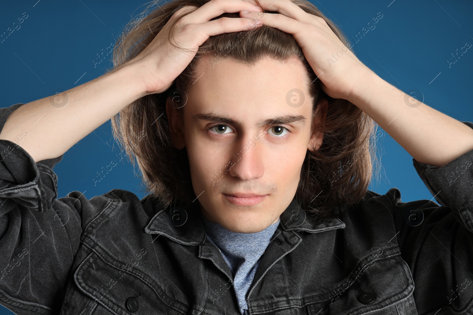 Photo of Portrait of young man on blue background, closeup