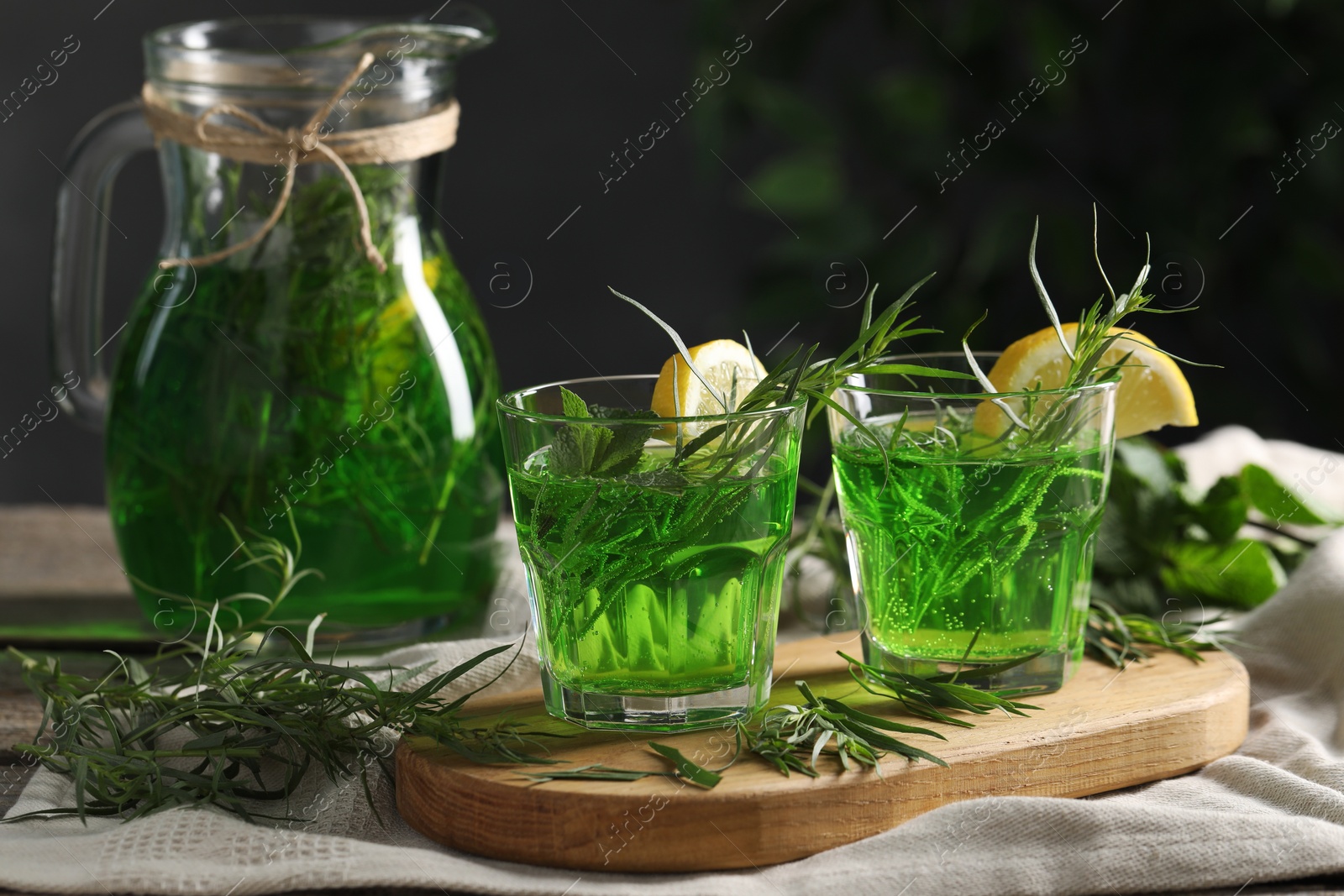 Photo of Refreshing tarragon drink with lemon slices on table