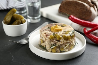 Photo of Delicious aspic with meat served on black slate table