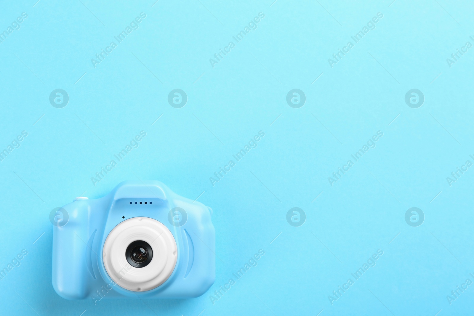 Photo of Toy camera on light blue background, top view. Space for text