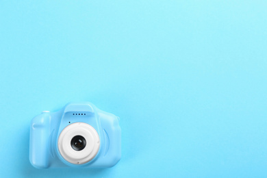 Toy camera on light blue background, top view. Space for text