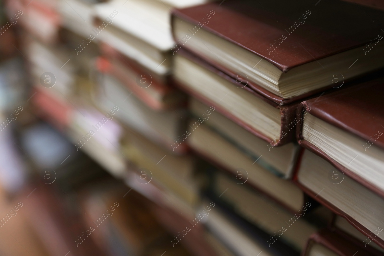 Photo of Stacks of books in library. Space for text
