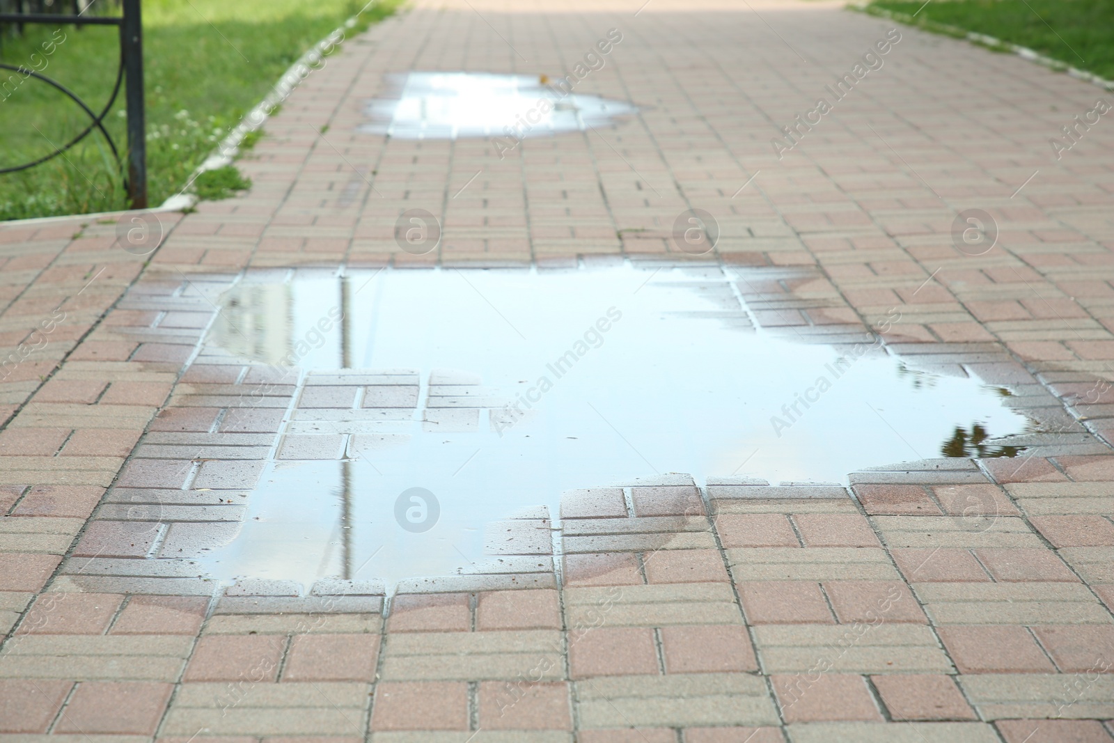 Photo of Puddle after rain on street tiles outdoors