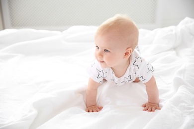 Photo of Cute little baby crawling on bed at home